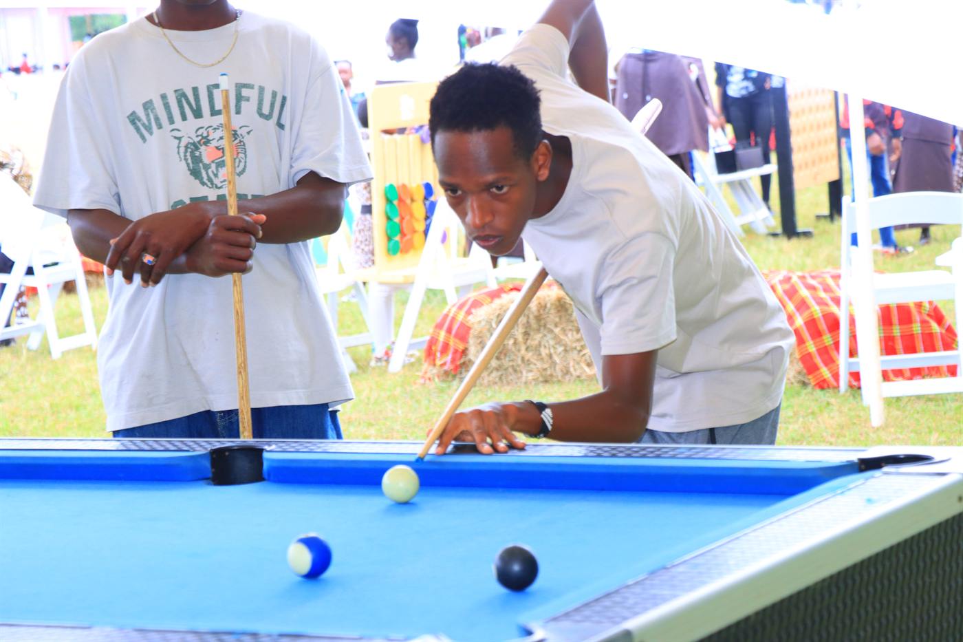 Two young men playing pool at the festival