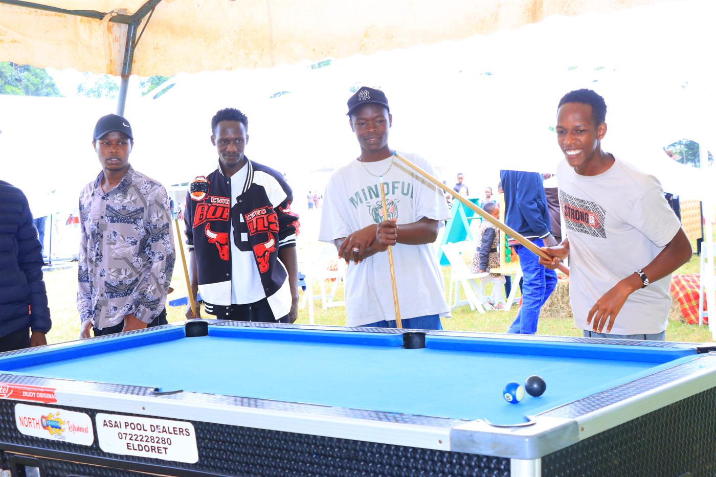 A group of young men with cues at a pool table