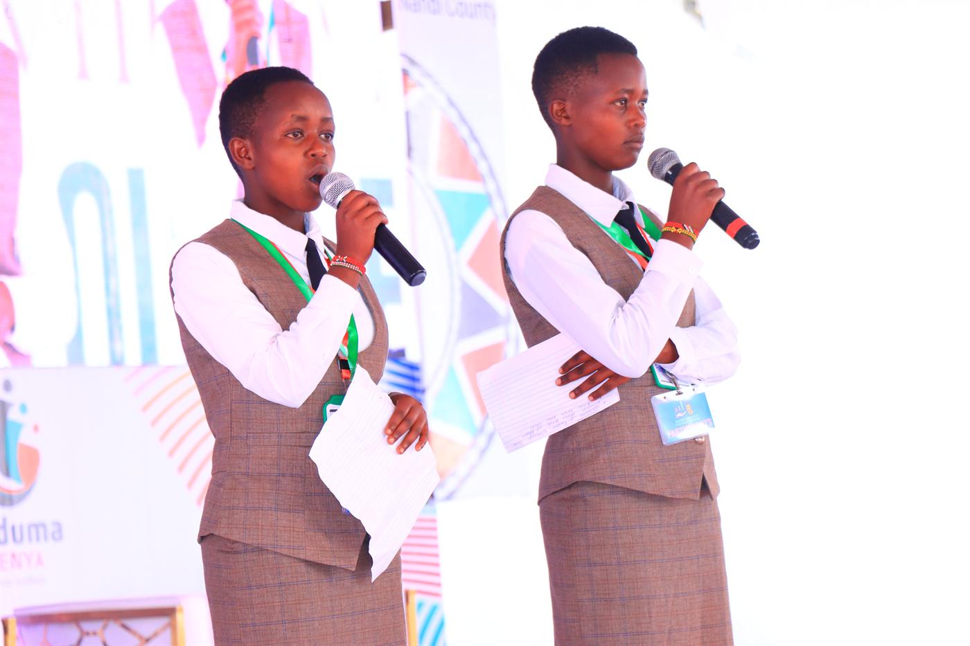 Two young hosts speaking on stage at the 2025 festival